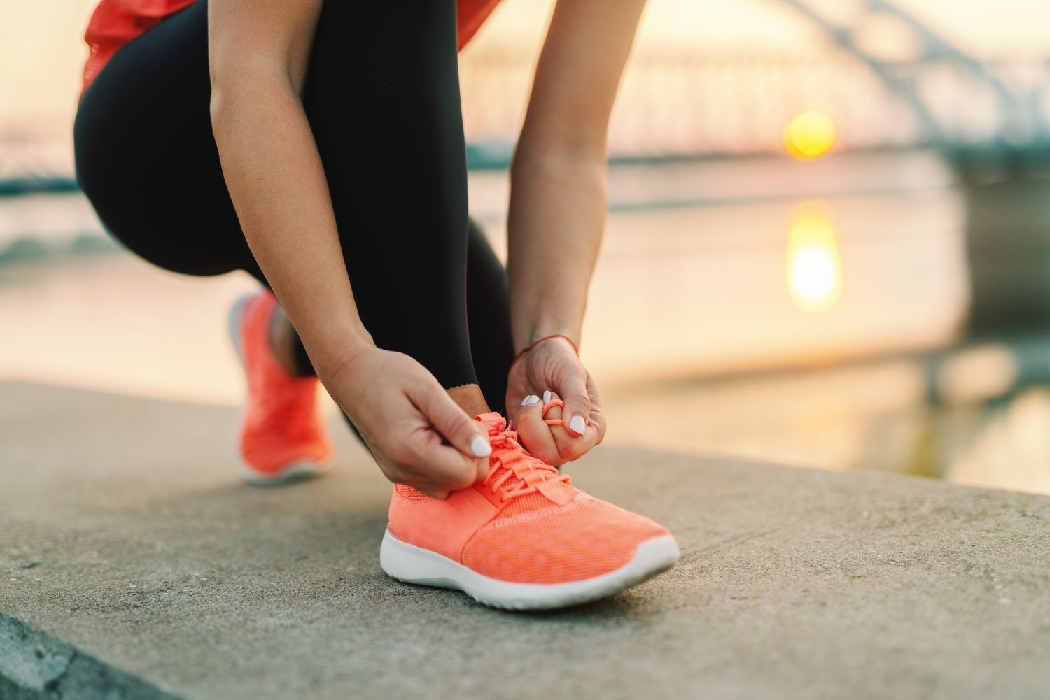 StepZone -StepZone close up of sporty woman tying shoelace while kneeling outdoor in background bridge fitness outdoors concept 1089844082 c50e1c2d537648e0a629312fe5f38121